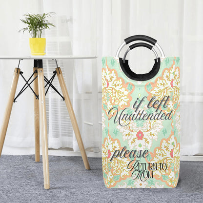 Decorative laundry basket with floral design and text in a room with a table and plant.