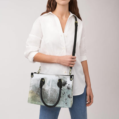 Woman holding a handbag with a white shirt and blue jeans on a plain background